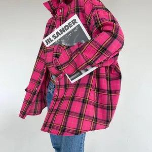 Vista dettagliata della trama a quadri rosa e nera su una camicia oversize a maniche lunghe