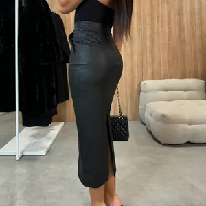 Elegant high waist black PU leather midi skirt with side slit and pocket details.