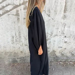 Side view of a black loose-fitting dress featuring elegant lantern sleeves and drapes.