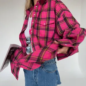 Dettaglio ravvicinato della camicia in flanella scozzese rosa da donna vestibilità oversize.