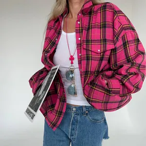 Dettaglio ravvicinato della camicia a quadri rosa oversize con risvolto e tasche