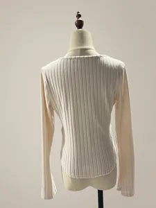 Detailed back view of a cream long sleeve ribbed slim fit top with a curved hem