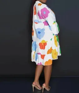 Side view of a loose white dress with vibrant oversized floral patterns and ruffled hem