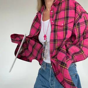 Primo piano di una camicia a quadri rosa vintage oversize a maniche lunghe.