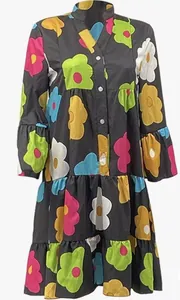 Detail view of a loose V-neck dress featuring vibrant floral prints and a tiered hem.