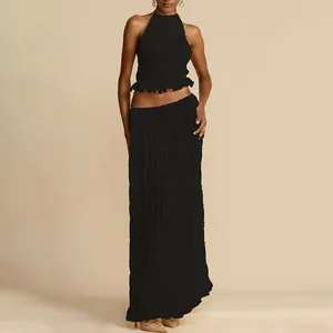 Ensemble élégant noir avec haut licou et jupe longue à volants pour les vacances.