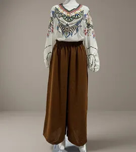 Loose high-waist brown wide-leg trousers shown on a mannequin in warehouse setting