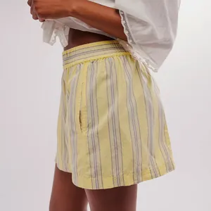 Side view detail of women's yellow striped casual shorts with elastic waist and pockets.