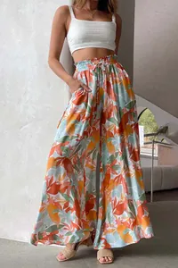 Detailansicht der bunten tropischen Blumenmuster auf sommerlichen High-Waist-Hosen.