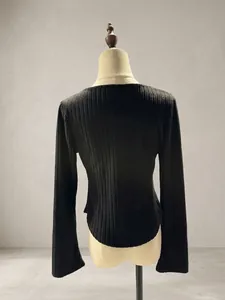 Back view detail of a black slim-fit ribbed long-sleeve top on a mannequin stand