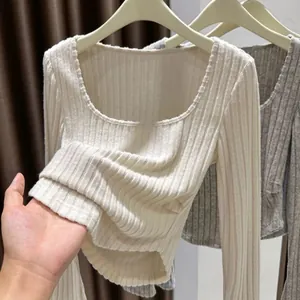 Detail view showing soft ribbed fabric of cream long sleeve shirt with square neck