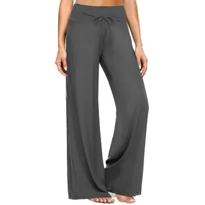 Dettaglio dei pantaloni fitness grigi a gamba larga con coulisse in vita sulla modella