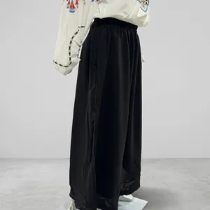 Detailed side view of black loose wide-leg pants with elastic waist