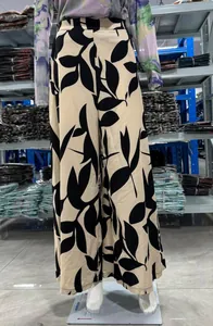 Détail du pantalon large à taille haute pour femme avec un imprimé feuille noir chic