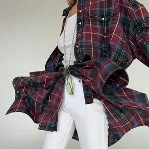 Dettaglio di una camicia a quadri bordeaux ampia che mostra il movimento del tessuto