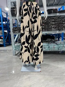 Pantalon large en mousseline pour femme avec taille haute et motif de feuilles noires.
