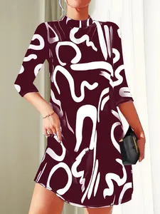 Close-up of stylish burgundy dress featuring white abstract brushstroke patterns and mock neck