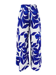 Vista detallada de los pantalones de talle alto y pernera ancha con estampado de hojas azules.