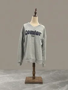 Detalle de sudadera gris con cuello en V y estampado COMFORT IN PARIS en almacén