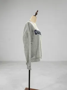 Vista lateral detallada de una sudadera gris con cuello en V e impresión de letras
