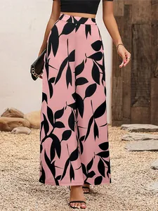 Détail d'un pantalon large en mousseline rose avec imprimé de feuilles noires et taille haute.