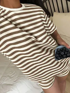 Close-up of brown and white striped short sleeve loungewear set on a bed