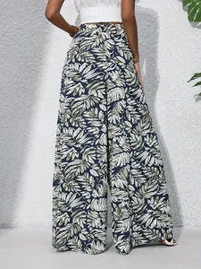 Back view of women's high-waisted wide-leg pants featuring a lush tropical leaf print