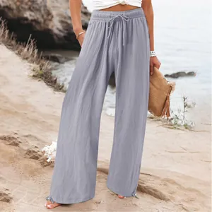 Women's casual light grey wide-leg trousers with elastic drawstring waist on beach.