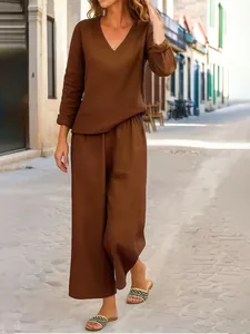 Vista intera di un completo casual marrone con scollo a V e pantaloni a gamba larga.