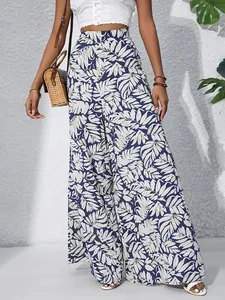 Detailed view of high-waisted wide-leg trousers with tropical leaf print for summer.