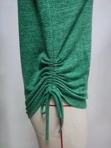 Close-up of green long sleeve t-shirt featuring adjustable drawstring ruched side detail.