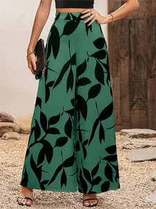 Vue détaillée d'un pantalon large en mousseline verte avec motif de feuilles noires.