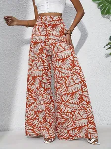 Close-up view of women's high-waisted wide-leg pants with orange tropical leaf print