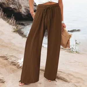 Detailed view of brown casual wide-leg pants with elastic drawstring waist on beach