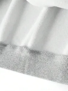 Detalle de sudadera gris que muestra el forro polar suave y la textura del dobladillo.
