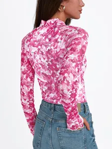 Detalle de la camiseta de malla con flores rosas y prácticos orificios para el pulgar