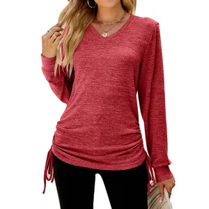 Detail view of women's long sleeve V-neck shirt showing side drawstrings on red fabric.