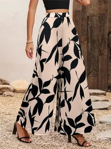 Détail du pantalon large à taille haute avec un élégant motif de feuilles noires.