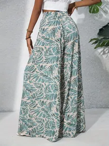 Back view of elegant women's high-waisted wide-leg trousers with tropical leaf print
