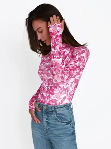 Detalle de top de malla con estampado floral rosa con mangas largas y orificios para pulgar