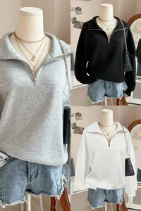 Dettaglio di felpe da donna con colletto a zip nei colori grigio, nero e bianco