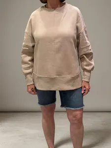 Close-up of loose round neck sweatshirt with batwing sleeves and ribbed cuffs