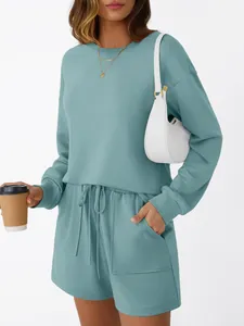 Modella indossa un set da casa blu-verde in due pezzi con maglia a maniche lunghe