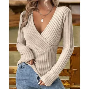 Detailed view of beige ribbed knit sweater showing cross V-neck and slim fit texture