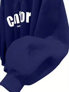 Detalle de sudadera azul marino con cuello en V, puños acanalados y estampado de letras blancas.