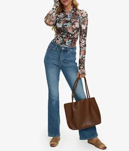 Detalle de camiseta de manga larga de malla floral con agujeros para el pulgar y cuello redondo.