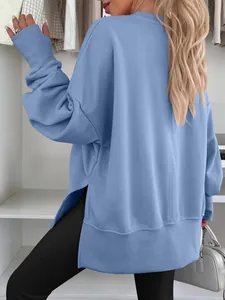 Back view of a blue oversized crewneck sweatshirt featuring side slits and batwing sleeves