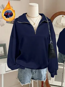 Dettaglio ravvicinato di una felpa oversize blu navy con mezza zip su manichino