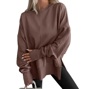 Close-up detail of a brown oversized sweatshirt featuring side slits and batwing sleeves.