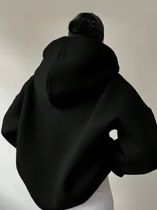 Rückenansicht eines minimalistischen schwarzen Oversize-Hoodies für Damen im Streetstyle